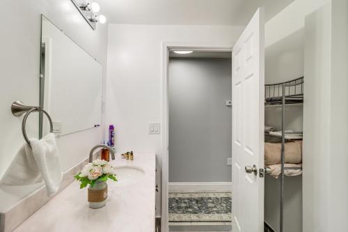 Baño blanco con lavabo y espejo en Farmington Hills Vacation Rental, 20 Mi to Detroit, en Farmington Hills