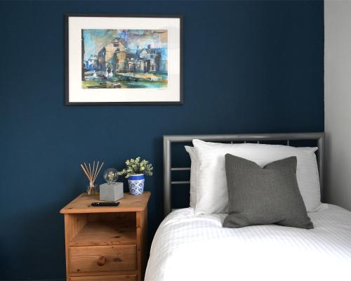 1 dormitorio con paredes azules, 1 cama y mesita de noche en Hermitage, 3 Bed entire House in Loughborough en Loughborough
