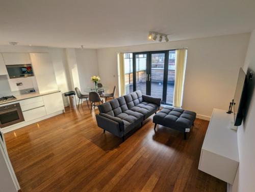 uma sala de estar com um sofá, cadeiras e uma mesa em NEW Lux 1 or 2 Bed Flats + Car Park + 5min Tube + Fast WiFi em Londres