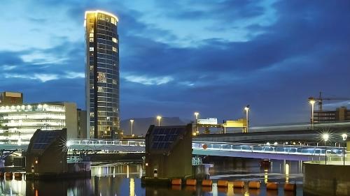 a city skyline with a tall building and a bridge at The Obel in Belfast