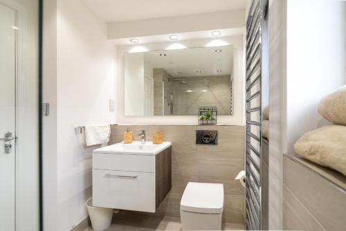 a bathroom with a toilet and a sink and a mirror at Amazing City Centre Home in Derby