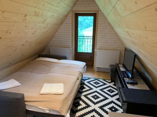 a bedroom with a bed and a desk in a attic at Bacówka Na Bundówkach in Zakopane