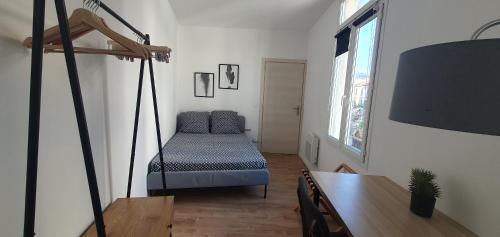 Cette chambre comprend une balancelle et une table. dans l'établissement BEL Appartement Neuf Lumineux, à Nice