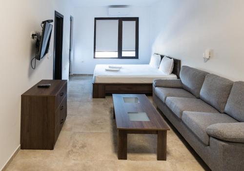 uma sala de estar com um sofá e uma cama em St George Apartcomplex em Shkorpilovtsi