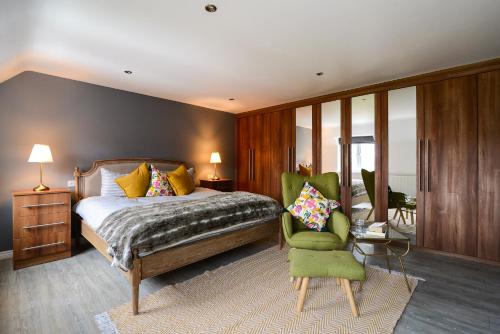 a bedroom with a bed and a green chair at Amazing City Centre Home in Derby