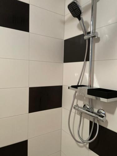 a black and white tile bathroom with a shower at Skönaste stället som finns. Bara 300 m till havet. in Lysekil