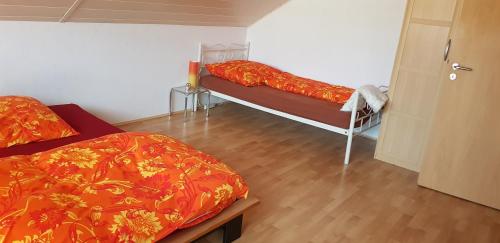 sypialnia z 2 łóżkami i drewnianą podłogą w obiekcie Ferienwohnung Karin w mieście Eltmann