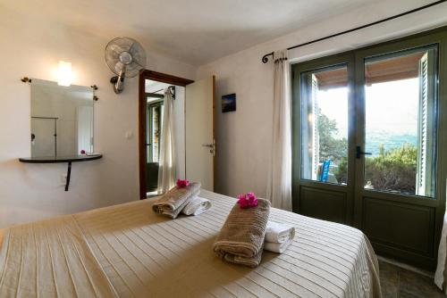 1 dormitorio con 1 cama con toallas y ventana en RURAL GUEST HOUSE B&B en Chavouna