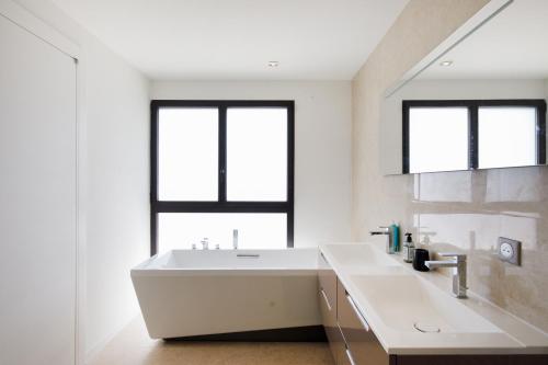 ein Badezimmer mit einem großen weißen Waschbecken und zwei Fenstern in der Unterkunft HSUD0059-Les Ecrins in Mougins