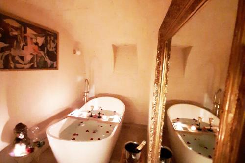 une salle de bain avec deux lavabos, une baignoire et un miroir dans l'établissement Guernica Apartment Paris Montmartre, à Paris