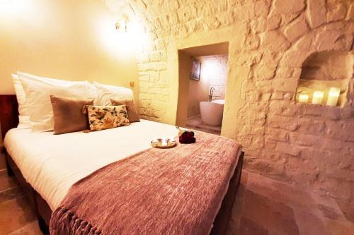 um quarto com uma cama numa parede de pedra em Guernica Apartment Paris Montmartre em Paris