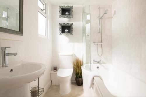 une salle de bain blanche avec un lavabo et des toilettes dans l'établissement Meadow - Woodland Cottage with Private Hot Tub, à Blandford Forum