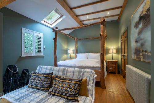 1 dormitorio con cama con dosel y ventana en Stable Lodge - Boutique Bed & Breakfast en Cheltenham