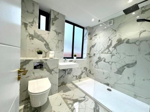 Baño blanco con aseo y lavamanos en Coastal 3BR Bournemouth Apartment, Prime Location, en Bournemouth