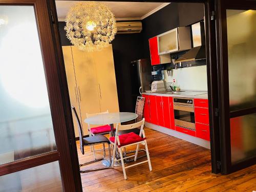 a kitchen with red cabinets and a table and chairs at Lovely place in Sofia