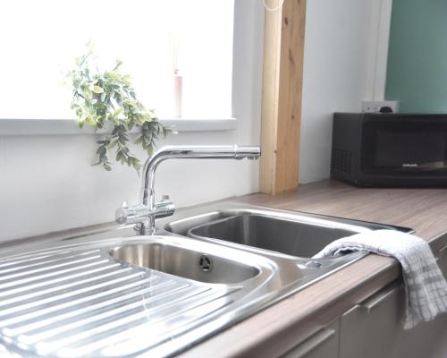 a stainless steel sink in a kitchen with a window at Hermitage, 3 Bed entire House in Loughborough in Loughborough