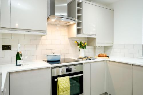 a white kitchen with white cabinets and an oven at Lucas in Sudbury