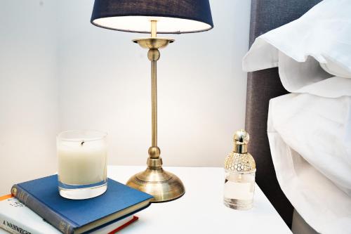 a lamp on a table with books and a candle at Lucas in Sudbury