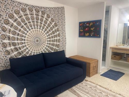 - un salon avec un canapé bleu en face d'un mur dans l'établissement ULYSSE, à Canet