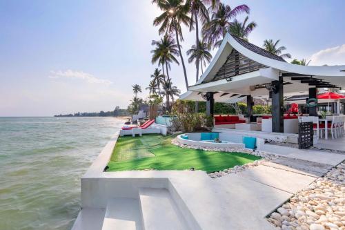 a house on the water with a beach at Beachfront Villa Baan Paradise in Laem Set Beach