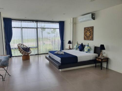 a bedroom with a bed and a large window at The Beach Resort & Residence - SHA Plus in Pathiu