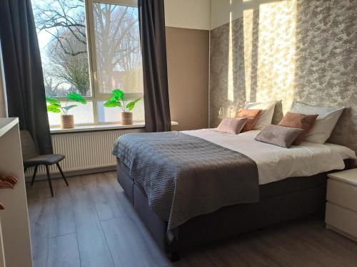 Un dormitorio con una cama grande y una ventana en B&B de Wilhelminaschool en Aalten