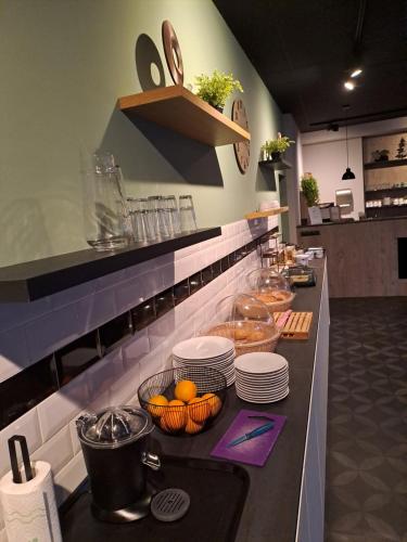 een keuken met een aanrecht met borden en sinaasappels erop bij B&B de Wilhelminaschool in Aalten