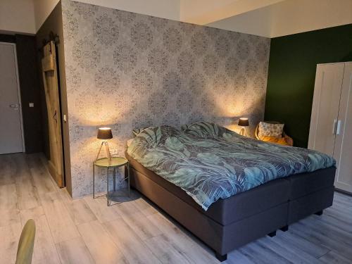 a bedroom with a bed and two lamps in it at B&B de Wilhelminaschool in Aalten