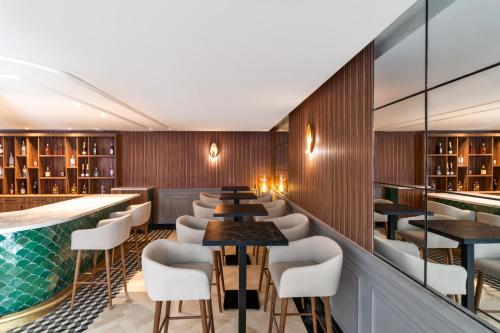 a restaurant with a pool and tables and chairs at Kenzi Rissani in Er Rachidia
