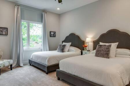 a bedroom with two beds and a window at Twin Homes of Art & Rooftops, Free Night Promo! in Nashville