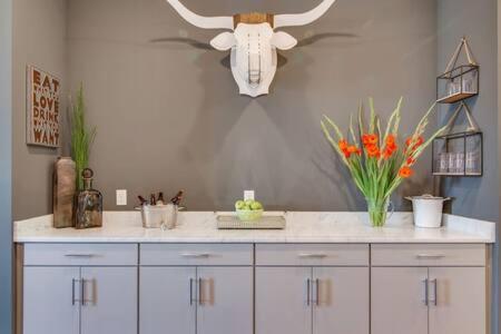 a white counter with a vase of flowers on it at Twin Homes of Art & Rooftops, Free Night Promo! in Nashville