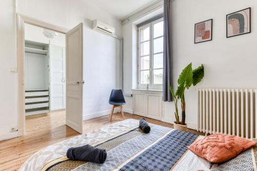 - une chambre avec des murs blancs et un tapis bleu au sol dans l'établissement Le Marty - wifi - central - climatison - parking gratuit, à Carcassonne