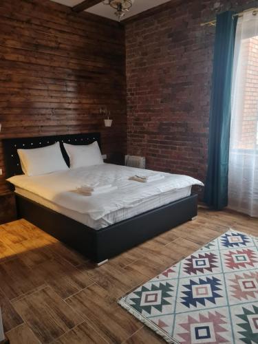 a bedroom with a bed and a brick wall at Conacul Ancuței in Brad