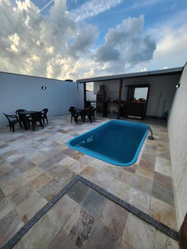 uma piscina num pátio com uma mesa e cadeiras em Casa 02 Almeida em Cabo Frio