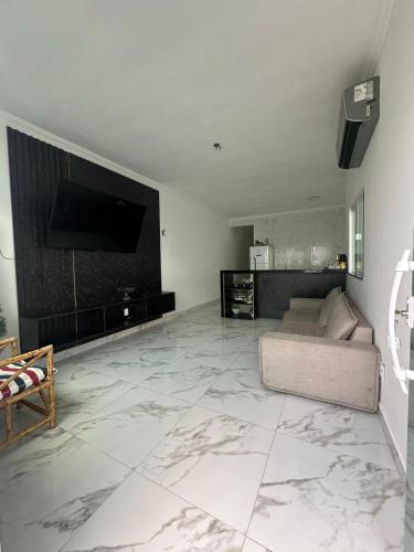 uma sala de estar com um sofá e uma televisão de ecrã plano em Casa 02 Almeida em Cabo Frio