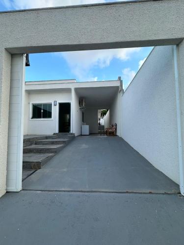 an open garage door of a white house at Casa 02 Almeida in Cabo Frio