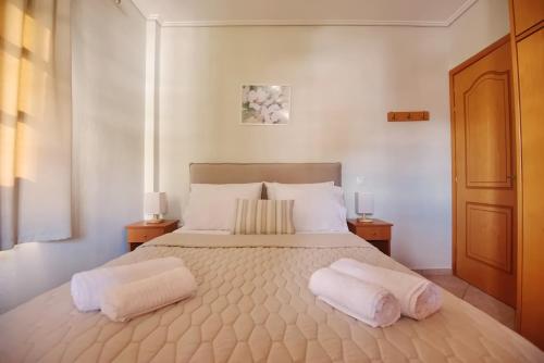 sypialnia z dużym łóżkiem z 2 białymi poduszkami w obiekcie Pefka Apartments w mieście Votsi