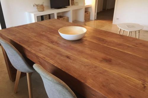 a wooden table with a bowl on top of it at L'OlivierBlanc in Vendémian