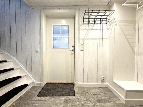 a hallway with a white door and a window at Idylliskt Hus Nära Lysekil & Skaftö in Uddevalla