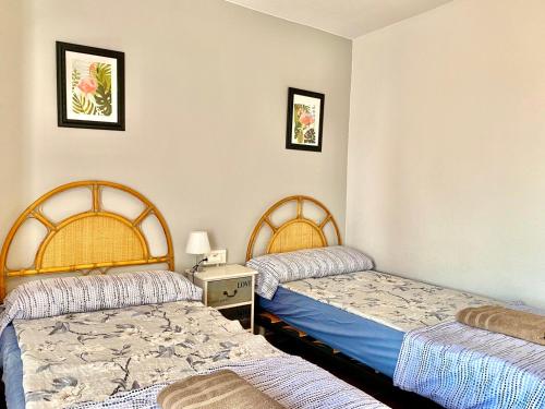 um quarto com 2 camas e uma mesa com um candeeiro em Apartament z widokiem na morze Playa de Los Naufragos em Torrevieja