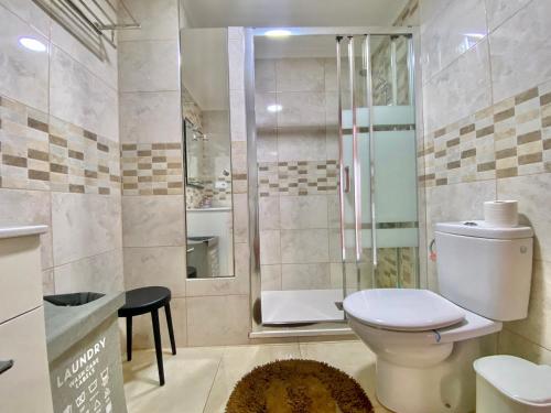 uma casa de banho com um WC e uma cabina de duche em vidro. em Apartament z widokiem na morze Playa de Los Naufragos em Torrevieja