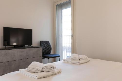a hotel room with a bed with towels on it at Angelico Modern Living in Florence