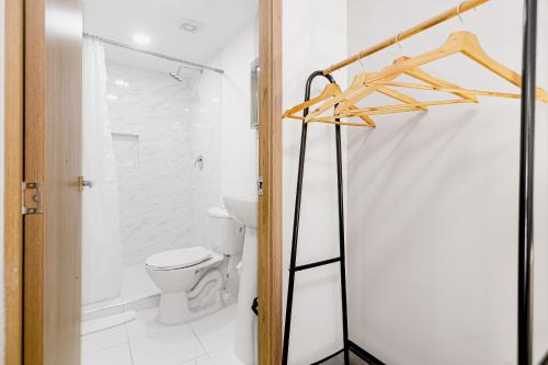 a white bathroom with a toilet and a shower at Bahari Cartagena Suites in Cartagena de Indias