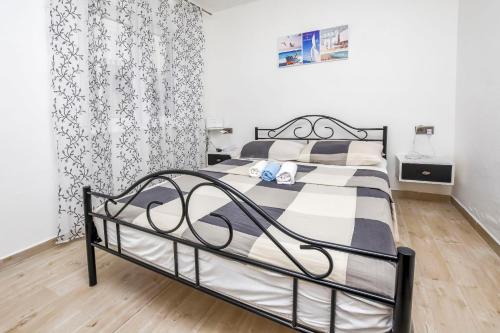 ein Schlafzimmer mit einem schwarz-weißen Bett in einem Zimmer in der Unterkunft House Lucija in Rogoznica