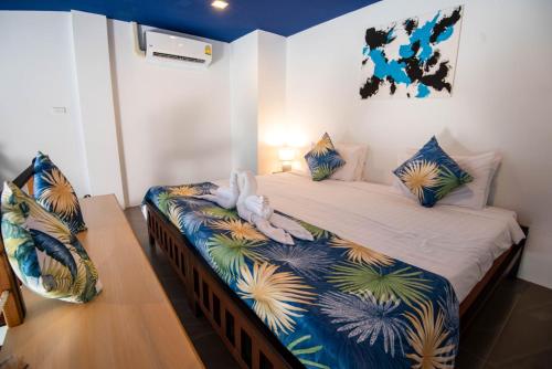 a bedroom with a bed with two swans on it at The Beach Resort & Residence - SHA Plus in Pathiu