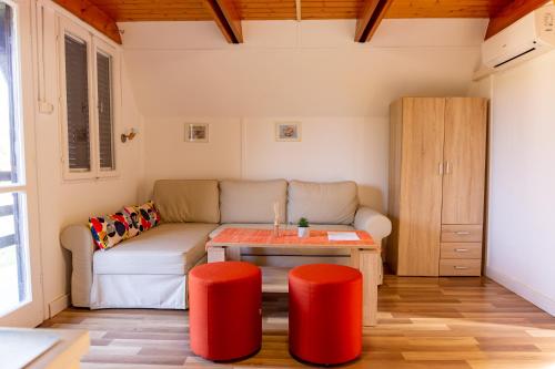 uma sala de estar com um sofá e uma mesa em Horizont idéző ParkMotel em Orfű