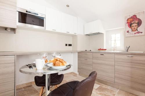 - une cuisine avec une table et une plaque de cuisson dans l'établissement LE PROVENCAL - Center old Antibes 1BR flat with AC, wifi, à Antibes