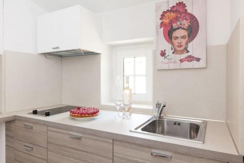 une cuisine avec un évier et un plan de travail dans l'établissement LE PROVENCAL - Center old Antibes 1BR flat with AC, wifi, à Antibes