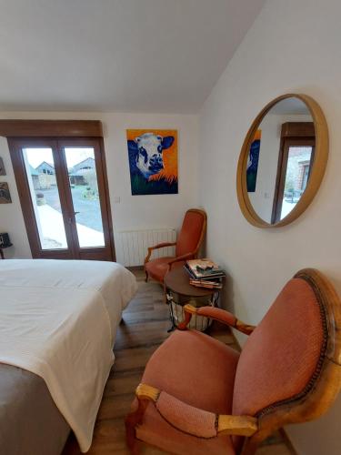 1 dormitorio con 1 cama, 2 sillas y espejo en Chambre table d'hôtes Anne-Marie et Jean-Christophe 
