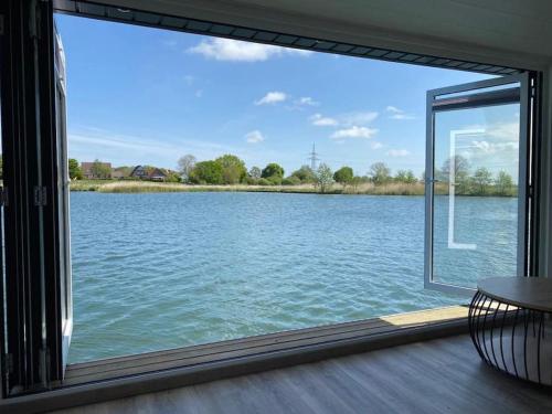 a view of a lake through a window at Hausboot Optimo mit Hund in Wangerland